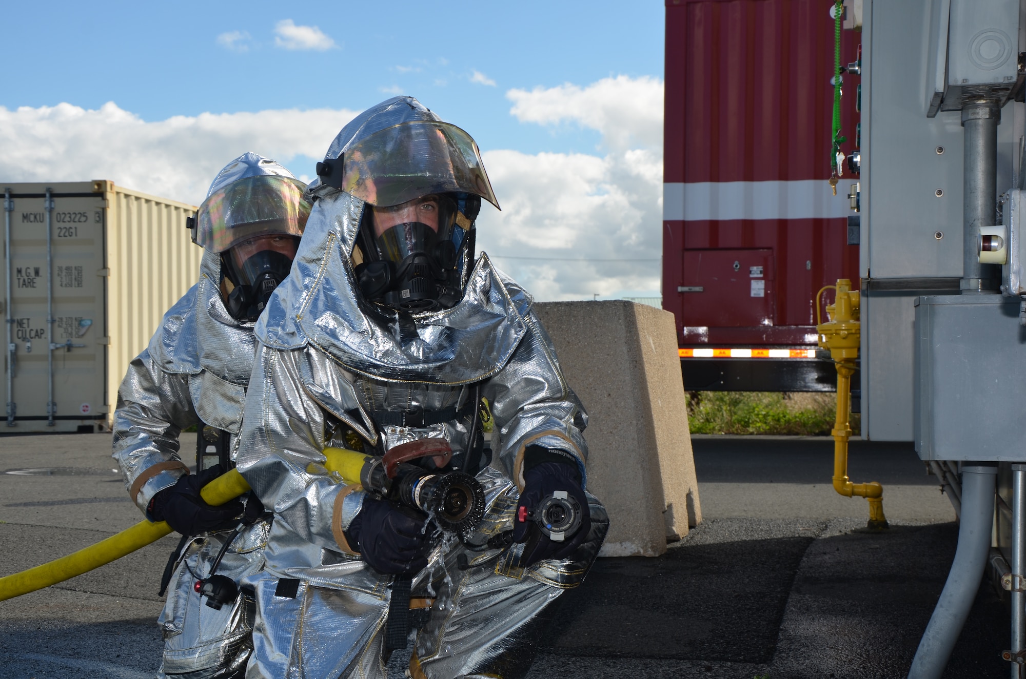 Senior Airman Davyn Thornburg, front, and Staff Sgt. Aladin Villalobos, back, firefighters with the 624th Civil Engineering Squadron, serve as backup firefighters during a live-fire burn exercise held during the reservists' unit training assembly, Hickam Field, Hawai'i, Jan. 10, 2015. Thornburg and Villalobos stand watch to enter the training structure if the two firefighters inside fighting the fire have a malfunction with their hose or need a break from the heat. (U.S. Air Force photo by Tech. Sgt. Phyllis Keith)