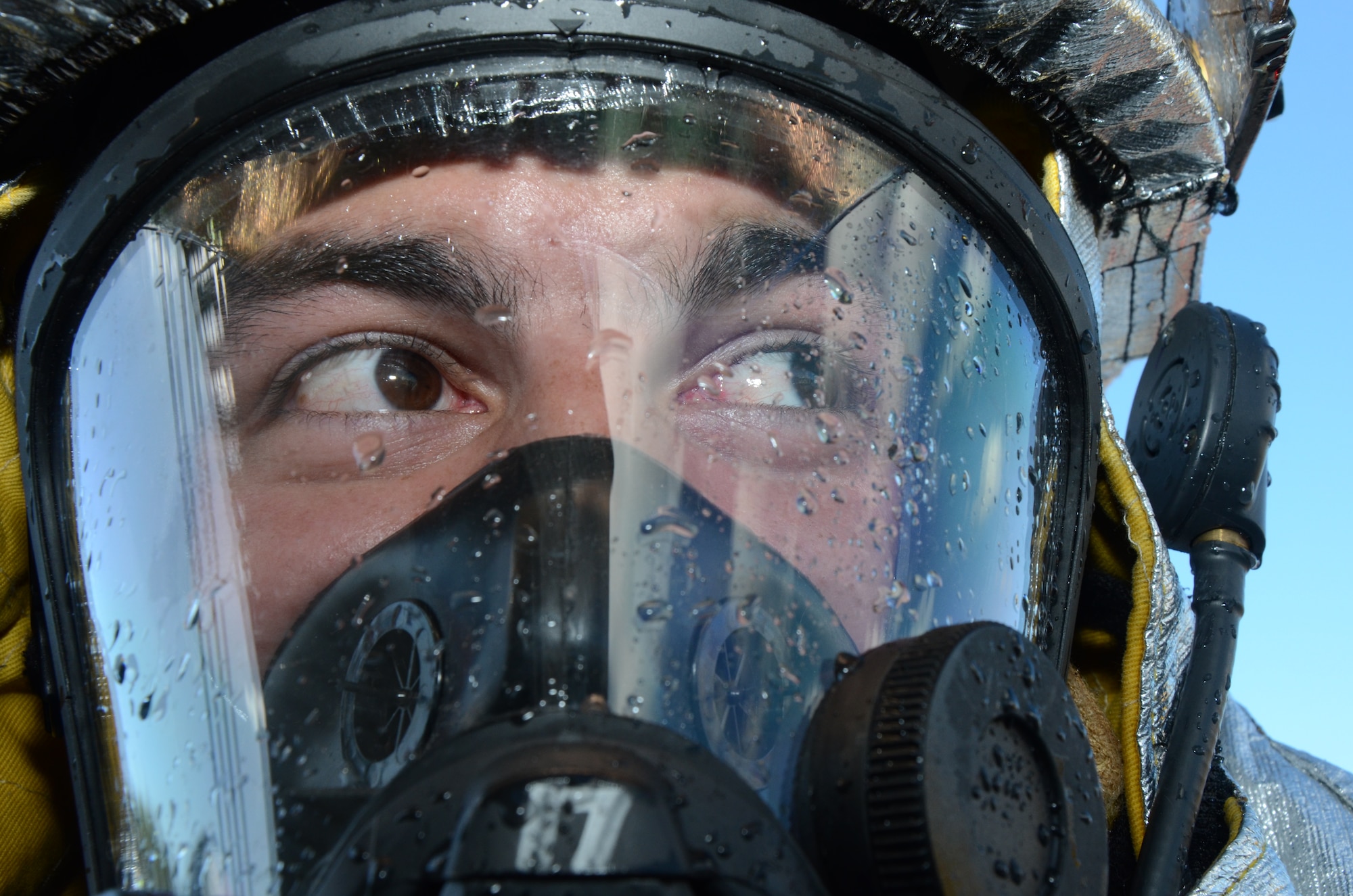 Water droplets cover Staff Sgt. Matthew Pires' oxygen mask after a live-fire burn training exercise conducted by the 624th Civil Engineering Squadron here at Hickam Field, Hawai'i, Jan. 10, 2015. Pires, a firefighter with the 624th CES, is a traditional reservist who works fulltime as a lieutenant in the State of Hawai'i Airport Fire Department, Kahului, Hawai'i on the island of Maui. (U.S. Air Force photo by Tech. Sgt. Phyllis Keith)