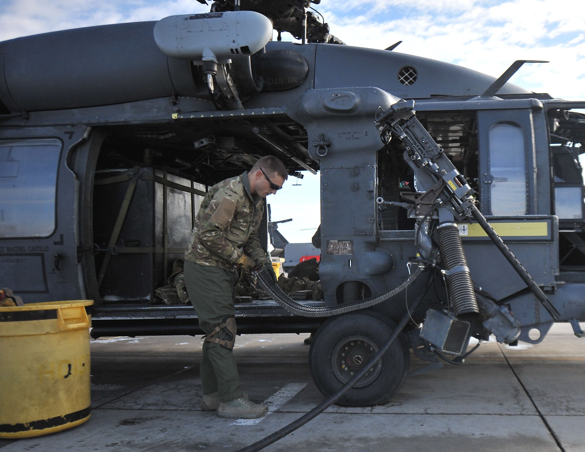 Tech. Sgt. Alex Rhynard, 66th Rescue Squadron special missions aviator evaluator, prepares a .50-caliber machine gun on an HH-60G Pave Hawk at Nellis Air Force Base, Nev., Jan. 12, 2015. Special missions aviators are responsible for performing maintenance on the weapon if it malfunctions as well as manning the weapon. (U.S. Air Force photo by Airman 1st Class Rachel Loftis)
