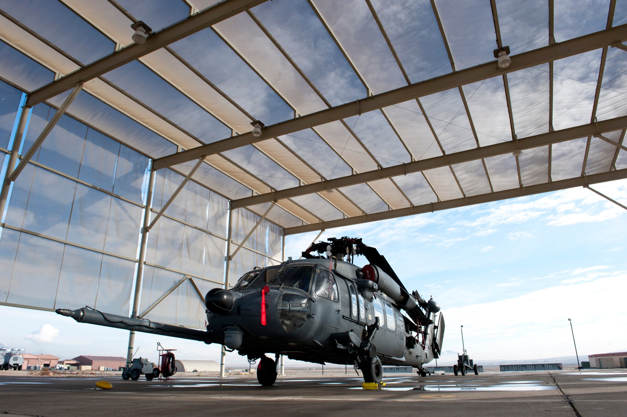 A U.S. Air Force HH-60G Pave Hawk assigned to the 66th Rescue Squadron sits on the tarmac at Nellis Air Force Base, Nev., Jan. 12, 2015. This HH-60 has its rotor blades folded back in preparation to be transported for deployment to southwest Asia. Airmen from the 823rd Maintenance Squadron are responsible for maintaining the aircraft also deploy with it to ensure it is mission ready to conduct combat search and rescue missions. (U.S. Air Force photo by Senior Airman Thomas Spangler)