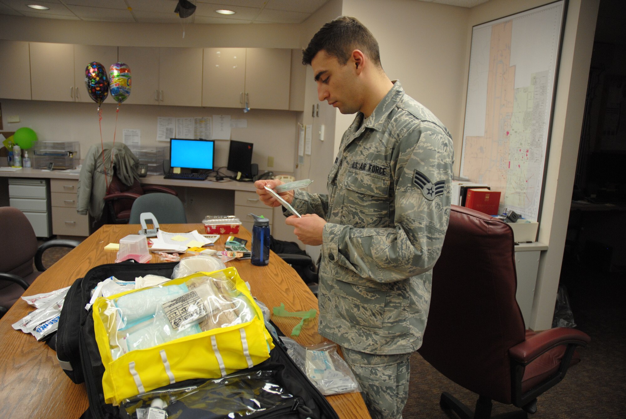 Senior Airman Joshua Coonich, 348th Reconnaissance Squadron aerospace medical technician, checks the expiration date and packaging of suringes in his mishap bag Dec. 24, 2014, at medical treatment facility on Grand Forks Air Force Base, N.D. The native from Schaumburg,Ill was named Grand Forks AFB's Warrior of the Week for the second week of January 2015. (U.S. Air Force photo/Staff Sgt. Luis Loza Gutierrez) 