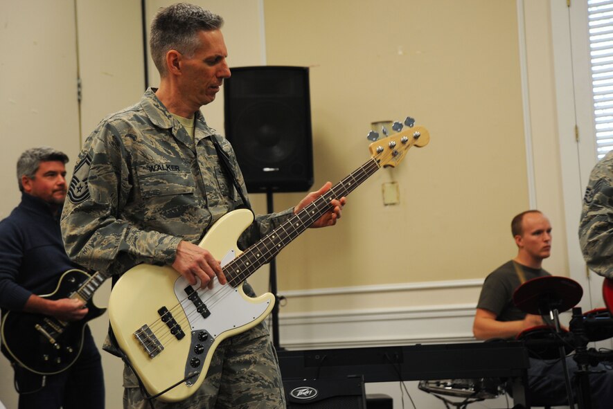 U.S. Air Force Senior Master Sgt. Richard Walker, 20th Medical Operations Squadron superintendent, plays a bass guitar before a 20th Medical Group annual awards ceremony at Shaw Air Force Base, S.C., Jan. 14, 2015. Walker and his band, primarily made of members assigned to the 20th MDG, played music before the ceremony to boost the morale of the crowd. (U.S. Air Force photo by Airman 1st Class Michael Cossaboom/Released)