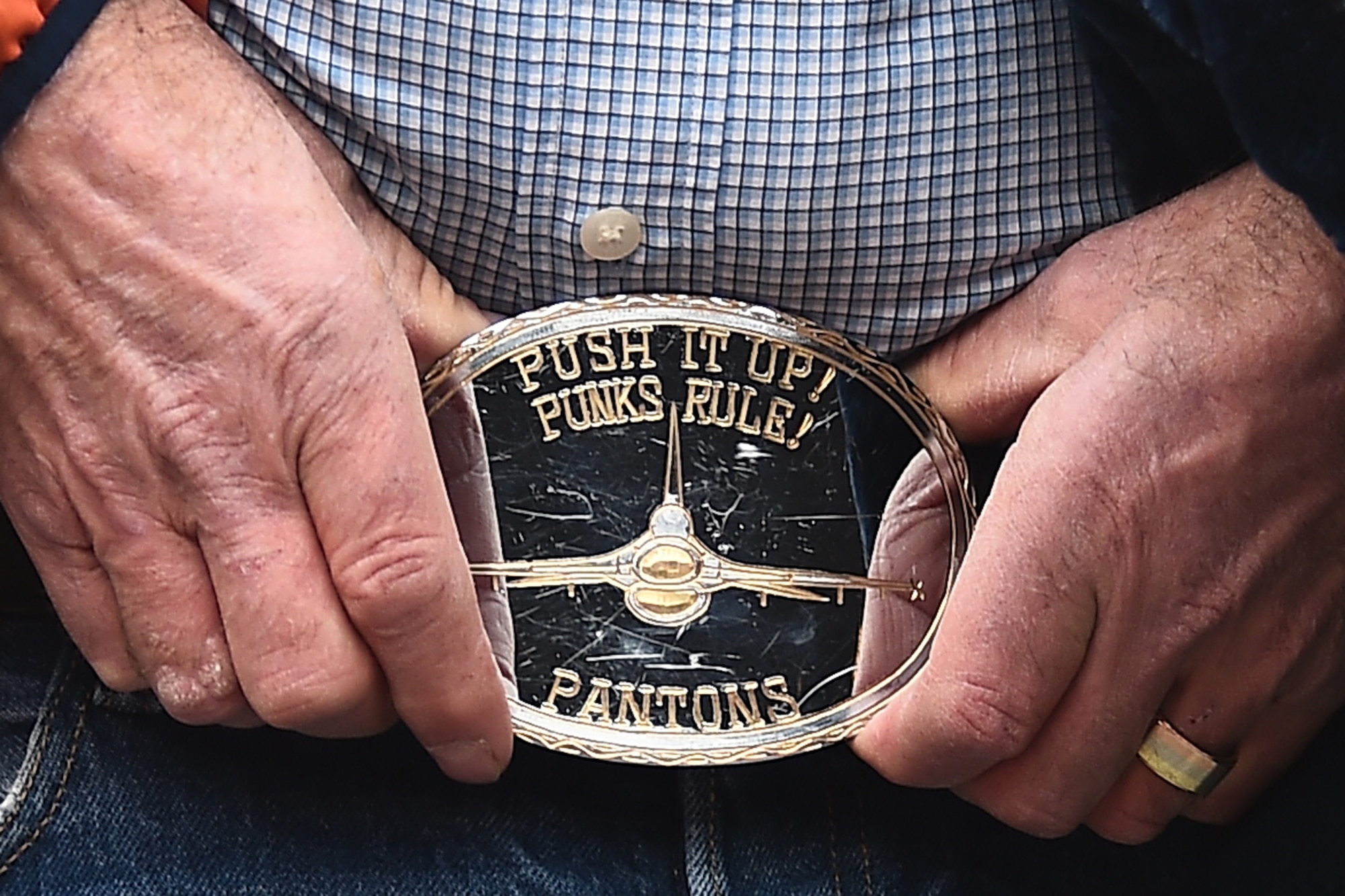 A belt buckle worn by William “Ham” DuBois, the father of Capt. William H. DuBois, is a memento to his son who lost his life in an F-16 Fighting Falcon accident while on deployment. The family of DuBois was presented the game ball before the Denver Broncos playoff game to honor his service and sacrifice.  (U.S. Air Force photo by Airman 1st Class Luke W. Nowakowski/Released)