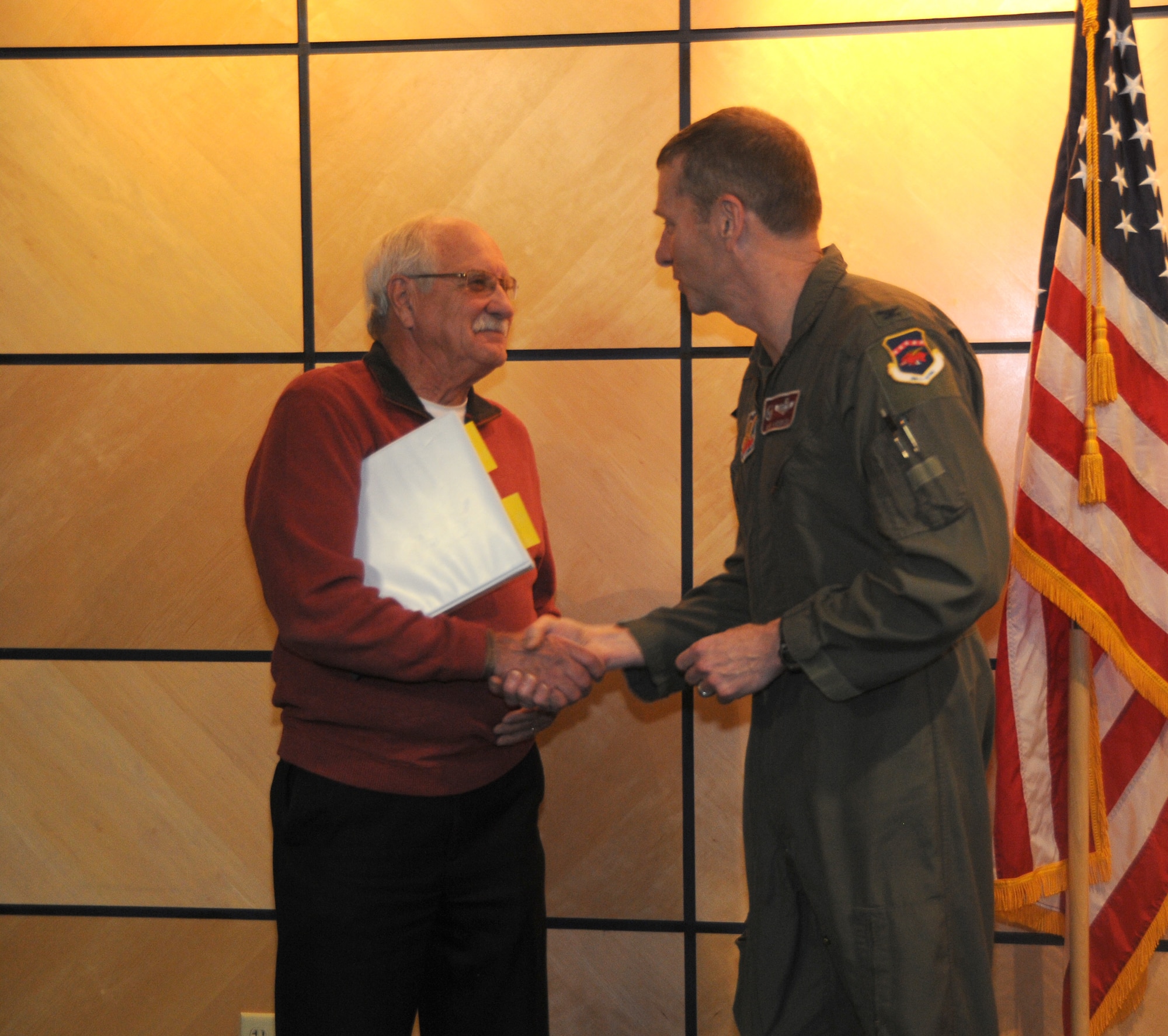 Col. Mark Anderson, 188th Wing commander, presents Mr. Larry Brown with a coin at Ebbing Air National Guard Base, Fort Smith, Ark., Jan. 9, 2015. Brown spoke to the service members about his son, U.S. Navy SEAL Adam Brown, whose story was made famous in the book "Fearless" by Eric Blehm. The book was written after his son made the ultimate sacrifice in support of Operation Enduring Freedom. (U.S. Air National Guard photo by Airman 1st Class Cody Martin/released) 