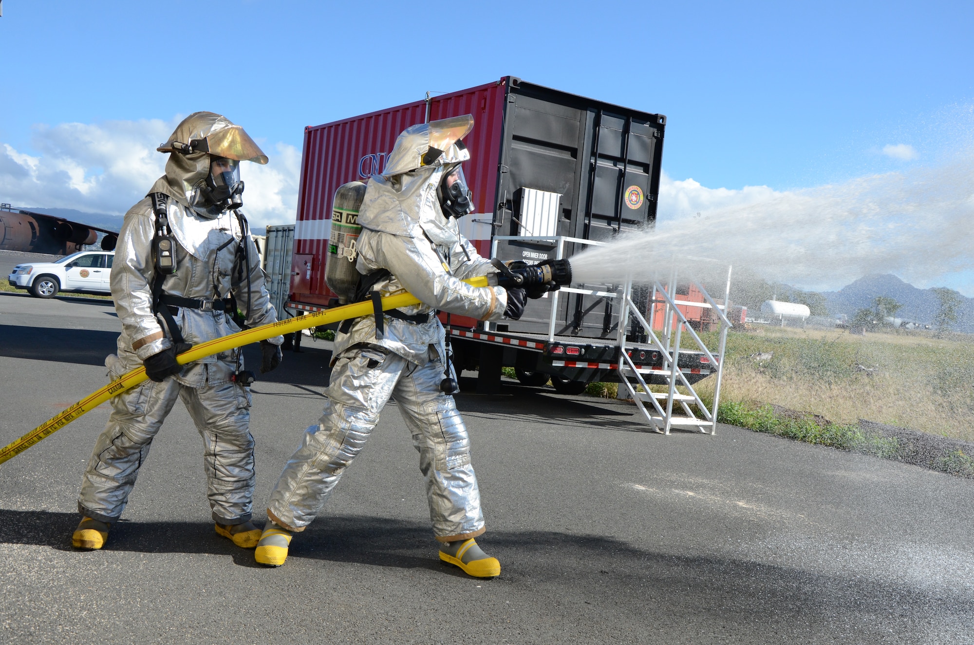 Staff Sgt. Jordan Fong-Aiu, left, and Senior Airman Warren Duke, right, firefighters with the 624th Civil Engineering Squadron, test a fire hose before participating in a live-fire burn exercise, Hickam Field, Hawai'i, Jan. 10, 2015. The Air Force Reserve fire department conducted their first hands-on training of the new year during their monthly unit training assembly. (U.S. Air Force photo by Tech. Sgt. Phyllis Keith)