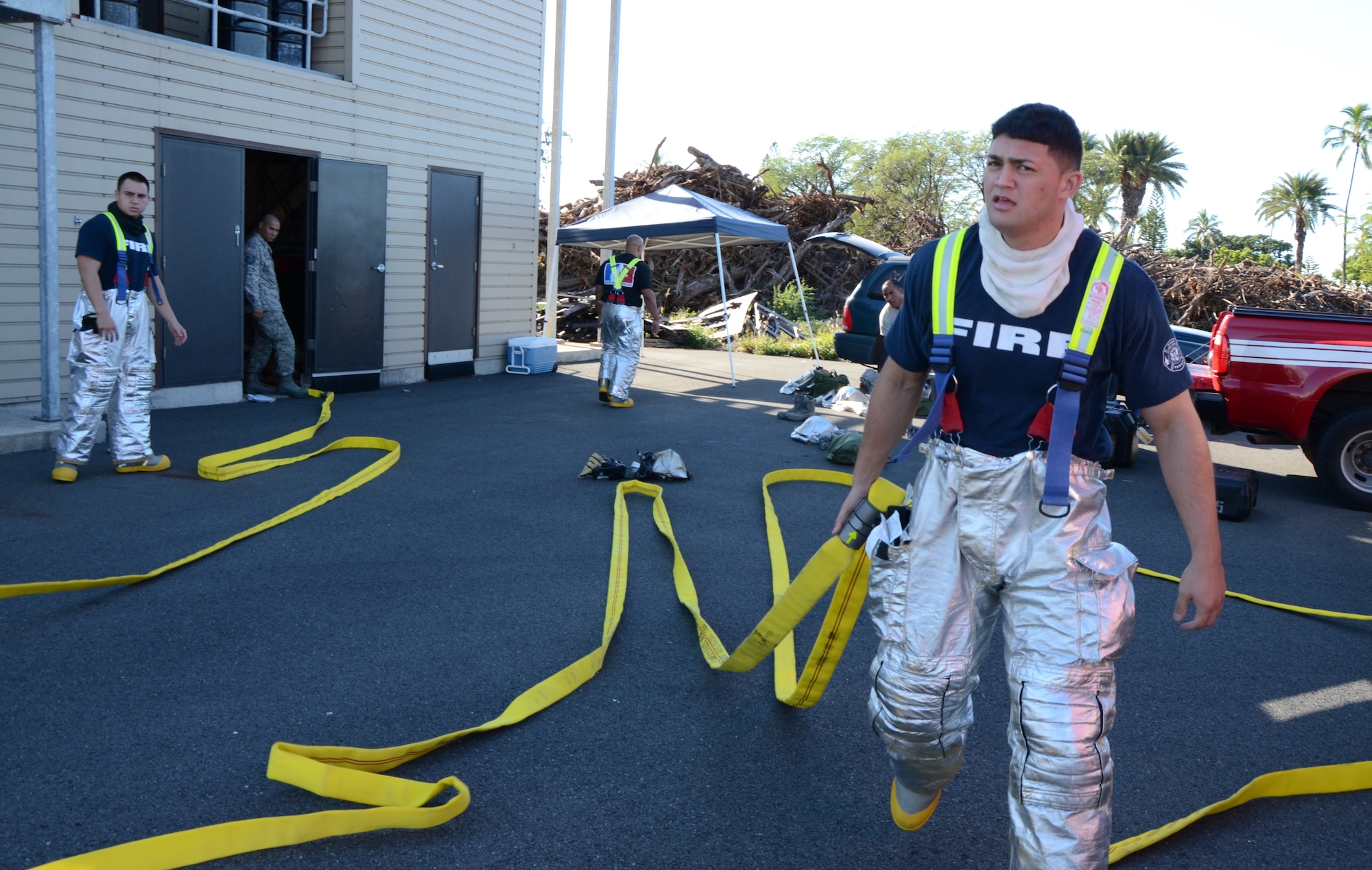 Senior Airman Warren Duke, front right, a firefighter with the 624th Civil Engineering Squadron, pulls a fire hose to lay it out in preparation for a live-fire training exercise at Hickam Field, Hawai'i, Jan. 10, 2015. (U.S. Air Force photo by Tech. Sgt. Phyllis Keith)