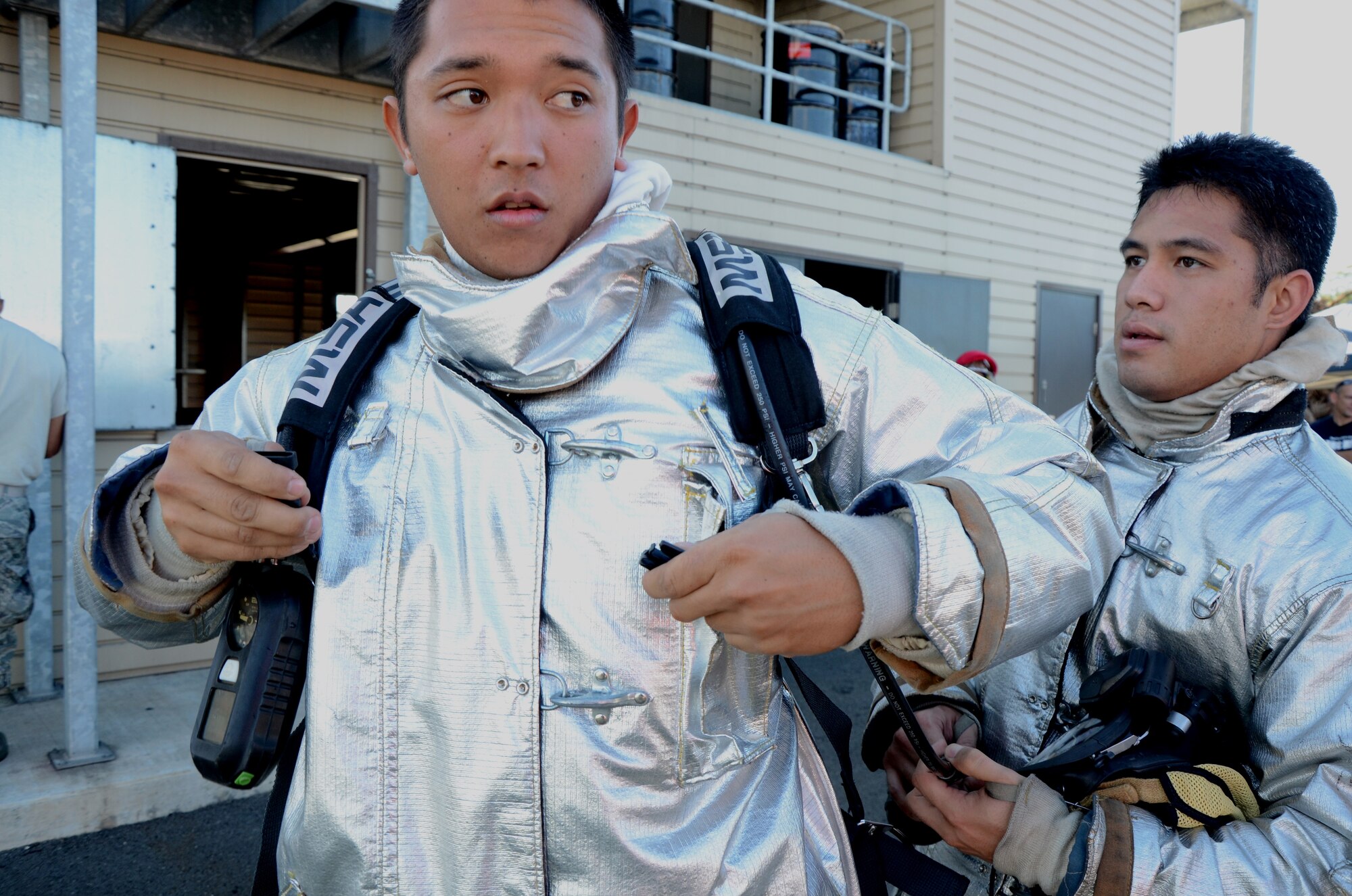 Senior Airman Michael Morgan, left, a firefighter with the 624th Civil Engineering Squadron, buckles his air pack while Staff Sgt. Michael Fong-Aiu, right, also a firefighter with the 624th CES,does a buddy check to make sure his gear is secure and he’s good-to-go, Hickam Field, Hawai'i, Jan. 10, 2015. The Air Force Reserve unit held a live-fire training exercise to fulfill an annual requirement. (U.S. Air Force photo by Tech. Sgt. Phyllis Keith)