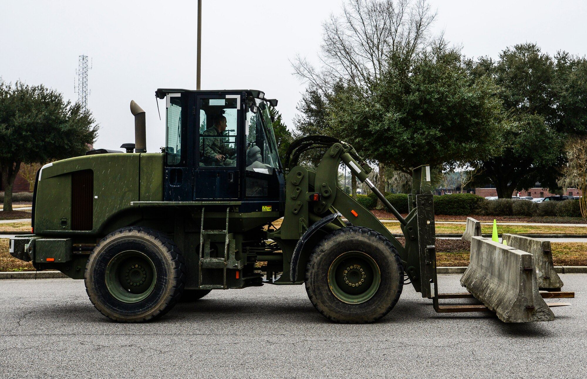 Airmen from the 628th Civil Engineer Squadron remove barriers from in front of base headquarters during an exercise Jan. 14, 2015, at Joint Base Charleston, S.C. JB Charleston held an exercise Jan. 14 through 15 to test the implementation of Force Protection levels in the event of an on base disturbance. (U.S. Air Force photo/ Senior Airman Dennis Sloan)