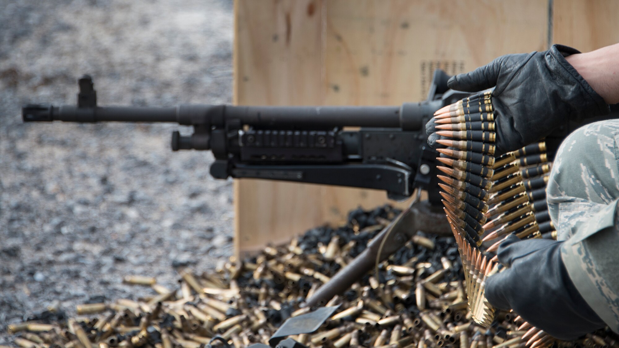 An Airman assigned to the 919th Special Operations Security Forces Squadron feeds the M240-B for his partner to complete heavy weapons qualification firing Jan 10, 2015 at Duke Field, Fla.  (U.S. Air Force photo/ Tech. Sgt. Jasmin Taylor)