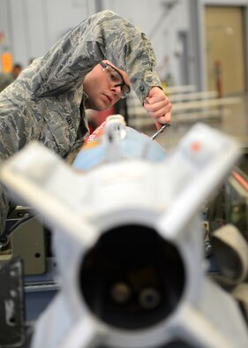 Airman 1st Class Kevin Gantt, 96th Aircraft Maintenance Unit Cobra 6 team member, tightens a bolt on a Guided Bomb Unit-12 during the quarterly weapons load competition inside the Weapons Load Training hanger on Barksdale Air Force Base, La., Jan. 9, 2015. Gantt was in charge of making sure all bombs were prepared and ready to load onto a B-52H Stratofortress. (U.S. Air Force photo/Senior Airman Joseph A. Pagán Jr.)