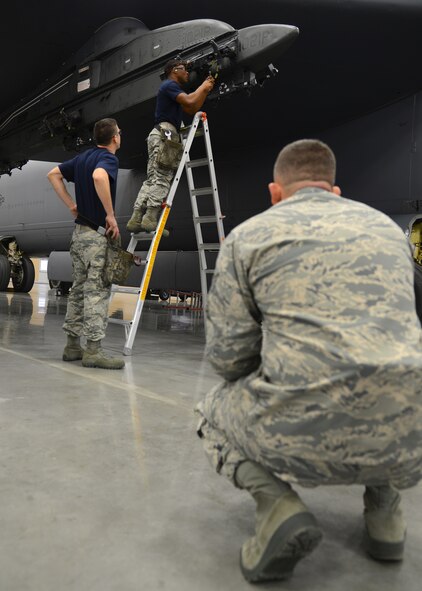 Staff Sgt. Jarrett Dodge, right, 2nd Maintenance Group loading standardization crew member, watches Senior Airman Benl Williams, 20th Aircraft Maintenance Unit Viper 6 team member, as he prepares a MAU-12 ejector rack for a weapon load inside the Weapons Load Training hanger on Barksdale Air Force Base, La., Jan. 9, 2015. Dodge was one of four inspectors observing the 20th and 96th AMU during the quarterly weapons load competition to see which unit could inspect, prepare and load weapons onto a B-52H Stratofortress with the least amount of discrepancies. (U.S. Air Force photo/Senior Airman Joseph A. Pagán Jr.)