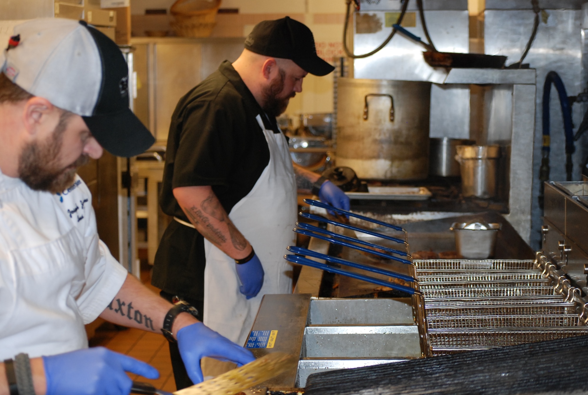 PETERSON AIR FORCE BASE, Colo. -- Club chef Joe Zamora (left) and sous chef Kirk Dunning create gourmet handmade hamburgers as new menu items available at The Club. The pub-style burgers are only one of the changes that have happened or will happen at the base restaurant. On-base pizza delivery and smoked barbecue items are slated for some time in 2015. (U.S. Air Force photo by Dave Smith)
 
