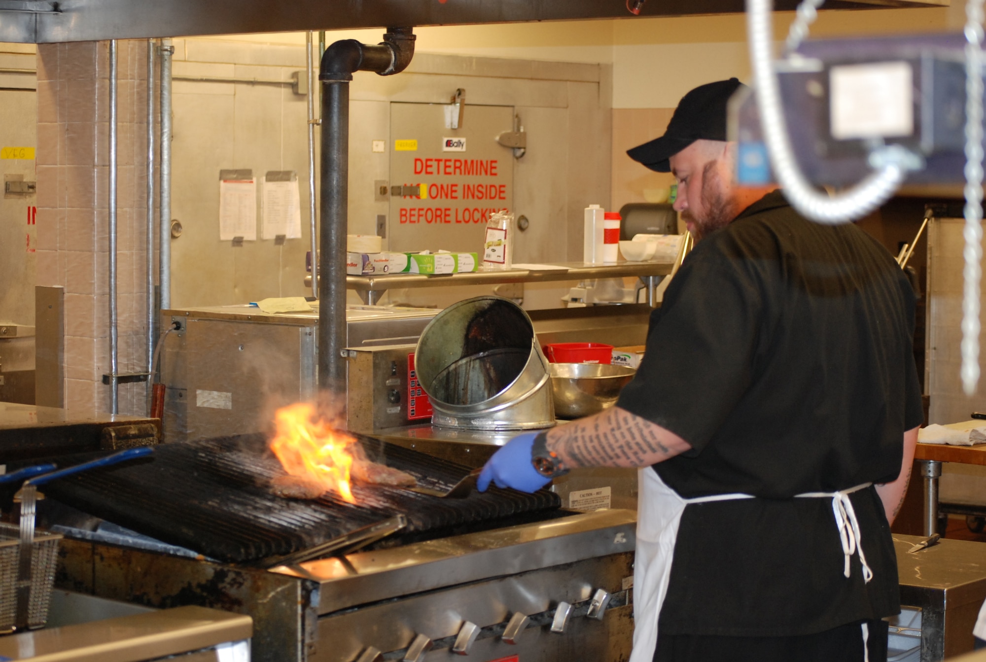 PETERSON AIR FORCE BASE, Colo. -- 21st Force Support Squad Peterson Club sous chef Kirk Dunning prepares hamburgers on the grill. Adding six gourmet pub-style burgers are just one of the changes at the base eatery, with more to come in 2015. (U.S. Air Force photo by Dave Smith)
 
