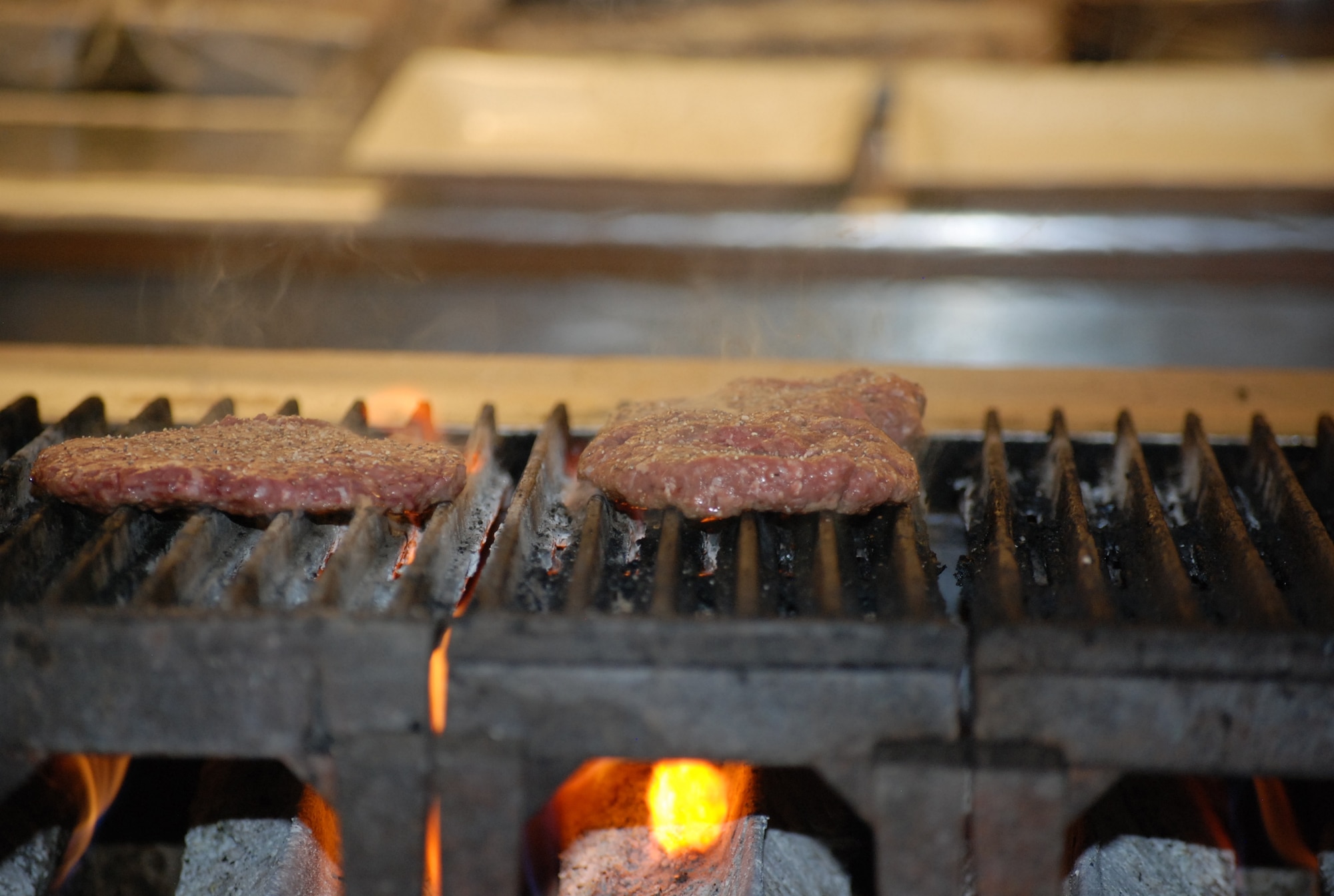 PETERSON AIR FORCE BASE, Colo. – Handcrafted hamburger patties are grilled over the flame before they are finished on the flat top in the kitchen at the Club. The patties go with one of the six new gourmet hamburgers now offered at the Club. (U.S. Air Force photo by Dave Smith)
 
