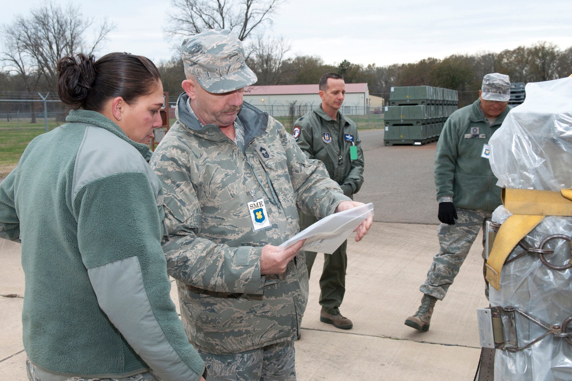 U.S. Air Force Tech. Sgt. Starlight Lesher waits for questions from an inspector while he reviews documents for an aircraft pallet loaded with mobility equipment for the 307th Security Forces Squadron, Jan. 9, 2015, Barksdale Air Force Base, La. The inspection was part of a mobility exercise the 307th Bomb Wing conducted during the January Unit Training Assembly. (U.S. Air Force photo by Master Sgt. Dachelle Melville/Released)