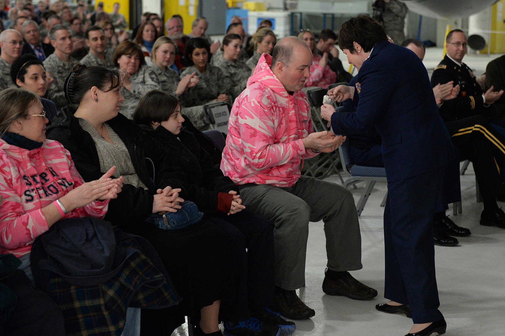 Brig. Gen. Gretchen S. Dunkelberger, Air National Guard assistant to Gen. Dorothy A. Hogg, presents Shawn Riley dog tags for him and his children as a way to remember the service of his wife, Lt. Col. Stephanie Riley, during a posthumous retirement ceremony in Hangar 254, Jan. 10. Riley, who passed away Dec. 29 at the age of 47, was an occupational health nurse for the N.H. National Guard assigned to Joint Force Headquarters in Concord. (U.S. Air National Guard photo by Tech. Sgt. Mark Wyatt)