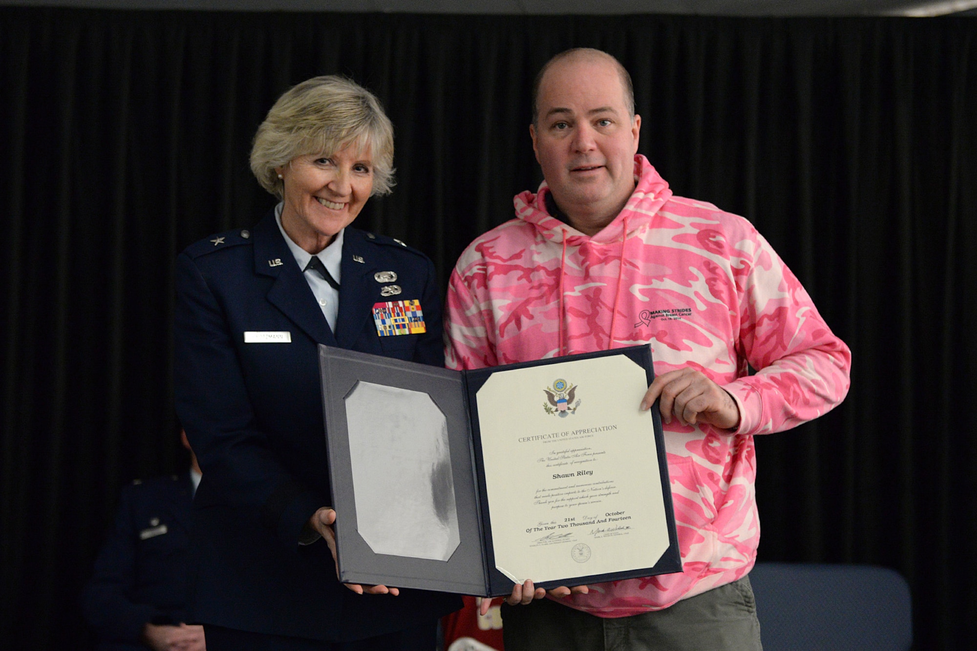 Brig. Gen. Carolyn J. Protzmann, N.H. Air National Guard commander, and Shawn Riley pose for a photo after a spouse presentation certificate of appreciation during a posthumous retirement ceremony for his wife, Lt. Col. Stephanie Riley, in Hangar 254, Jan. 10. Riley, who passed away Dec. 29 at the age of 47, was an occupational health nurse for the N.H. National Guard and longtime member of the 157th Medical Squadron. (U.S. Air National Guard photo by Tech. Sgt. Mark Wyatt)