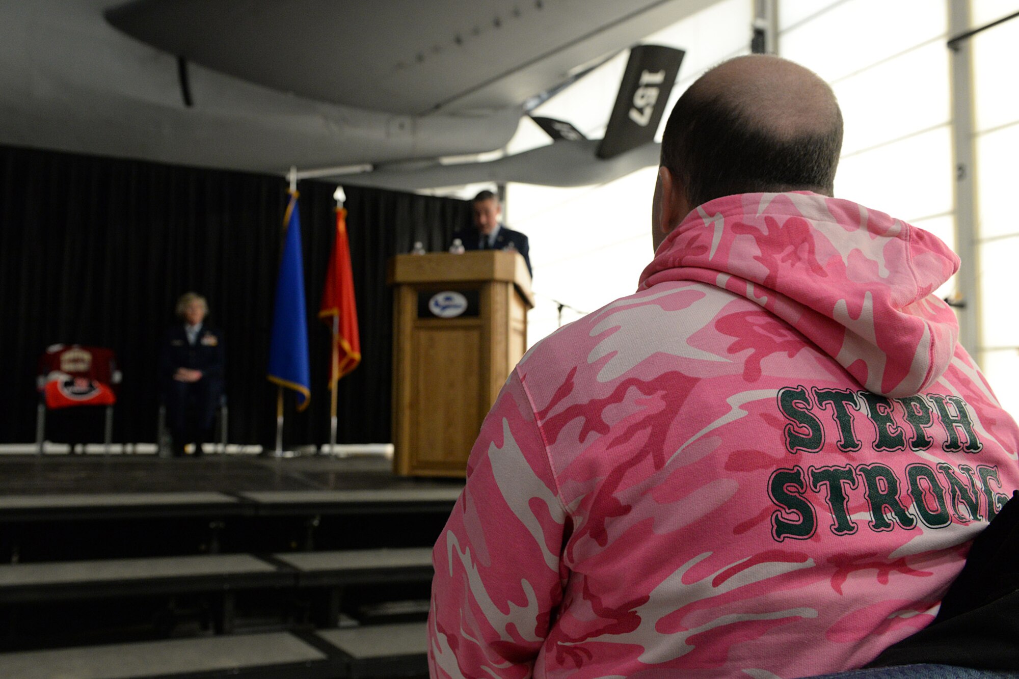 Shawn Riley, husband of Lt. Col. Stephanie Riley who passed away Dec. 29 at the age of 47, sits in the front row wearing a ‘Steph Strong’ sweatshirt during a posthumous retirement ceremony for his wife in Hangar 254, Jan. 10. Riley, a N.H. National Guard occupational health nurse, became an advocate after her diagnosis she for people to take the signs your body is showing more seriously.  (U.S. Air National Guard photo by Tech. Sgt. Mark Wyatt)