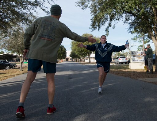 A participant is cheered to the finish line during the Resolution 5k run Jan. 10 at Duke Field, Fla.  The proceeds benefit the Senior Airman Josh Santos Memorial.  More than 50 people participated.  (U.S. Air Force photo/Tech. Sgt. Jasmin Taylor)