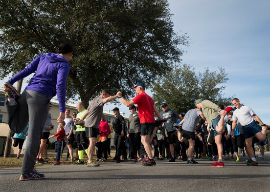1st Lt Linda McCulough, 919th Special Operations Maintenance Group, led the group stretches during the Resolution 5k run Jan. 10 at Duke Field, Fla.  The proceeds benefit the Senior Airman Josh Santos Memorial.  More than 50 people participated.  (U.S. Air Force photo/Tech. Sgt. Jasmin Taylor)