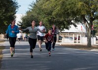 1st Lt Bobbiejean Johnson, 919th Special Operations Wing, races a young contestant to the finish line during the Resolution 5k run Jan. 10 at Duke Field, Fla.  The proceeds benefit the Senior Airman Josh Santos Memorial.  More than 50 people participated.  (U.S. Air Force photo/Tech. Sgt. Jasmin Taylor)