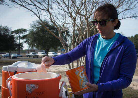 1st Lt Linda McCulough, 919th Special Operations Maintenance Group, pours Gatorade powder into the water jugs to prepare for the Resolution 5k run Jan 10 at Duke Field, Fla.  The proceeds benefit the Senior Airman Josh Santos Memorial.  More than 50 people participated.  (U.S. Air Force photo/Tech. Sgt. Jasmin Taylor)