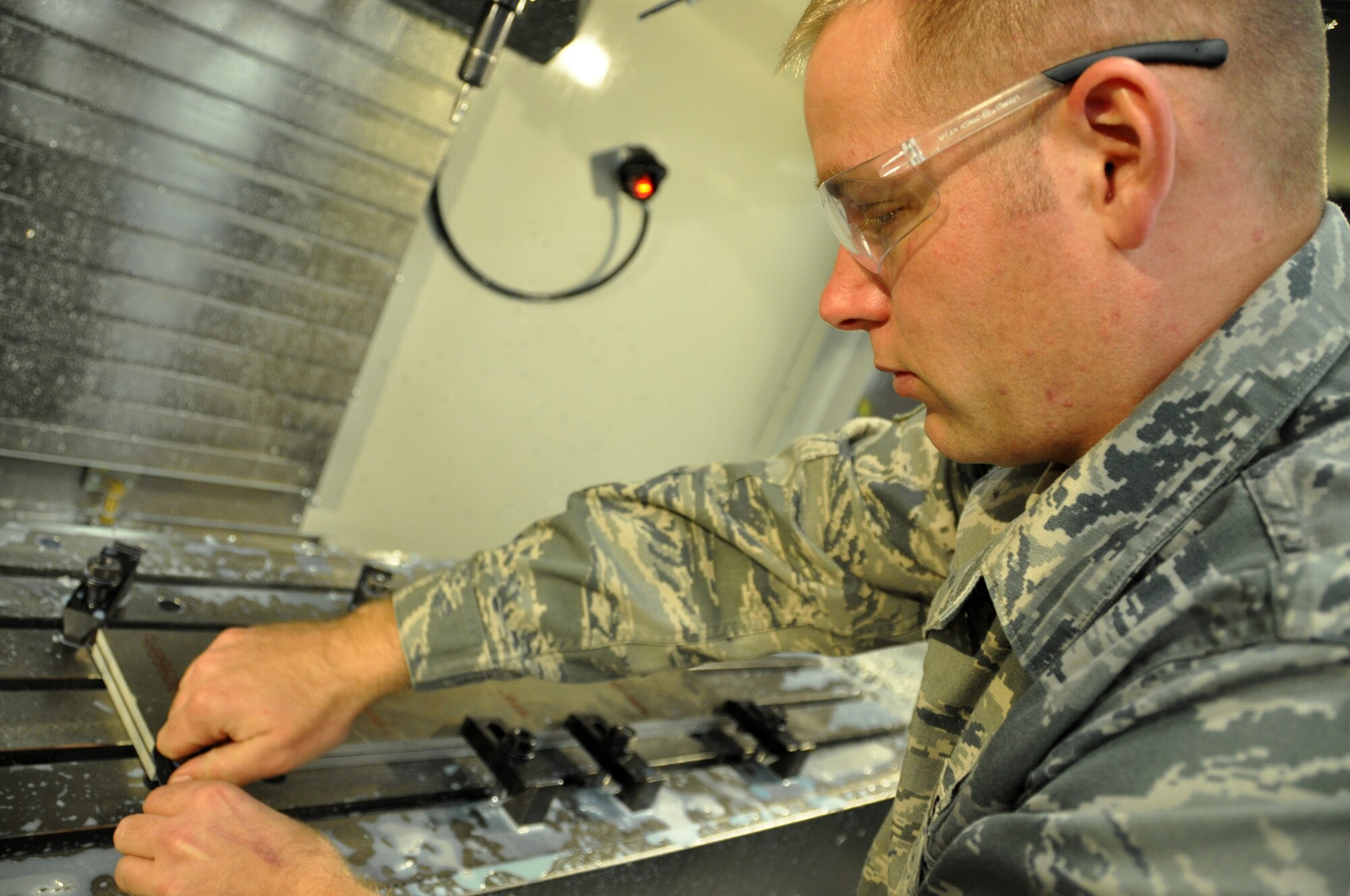 Master Sgt. Kristopher Prouty, an aircraft metals technology craftsman, supervises equipment in his shop at Moody AFB, Ga. on 10 January, 2015.  In addition hands-on production and repair projects, Prouty programs heavy machinery, which draws on his understanding of trigonometry and chemistry. He is currently completing his master’s degree in project management. (Air Force photo by Tech. Sgt. Emily F. Alley)