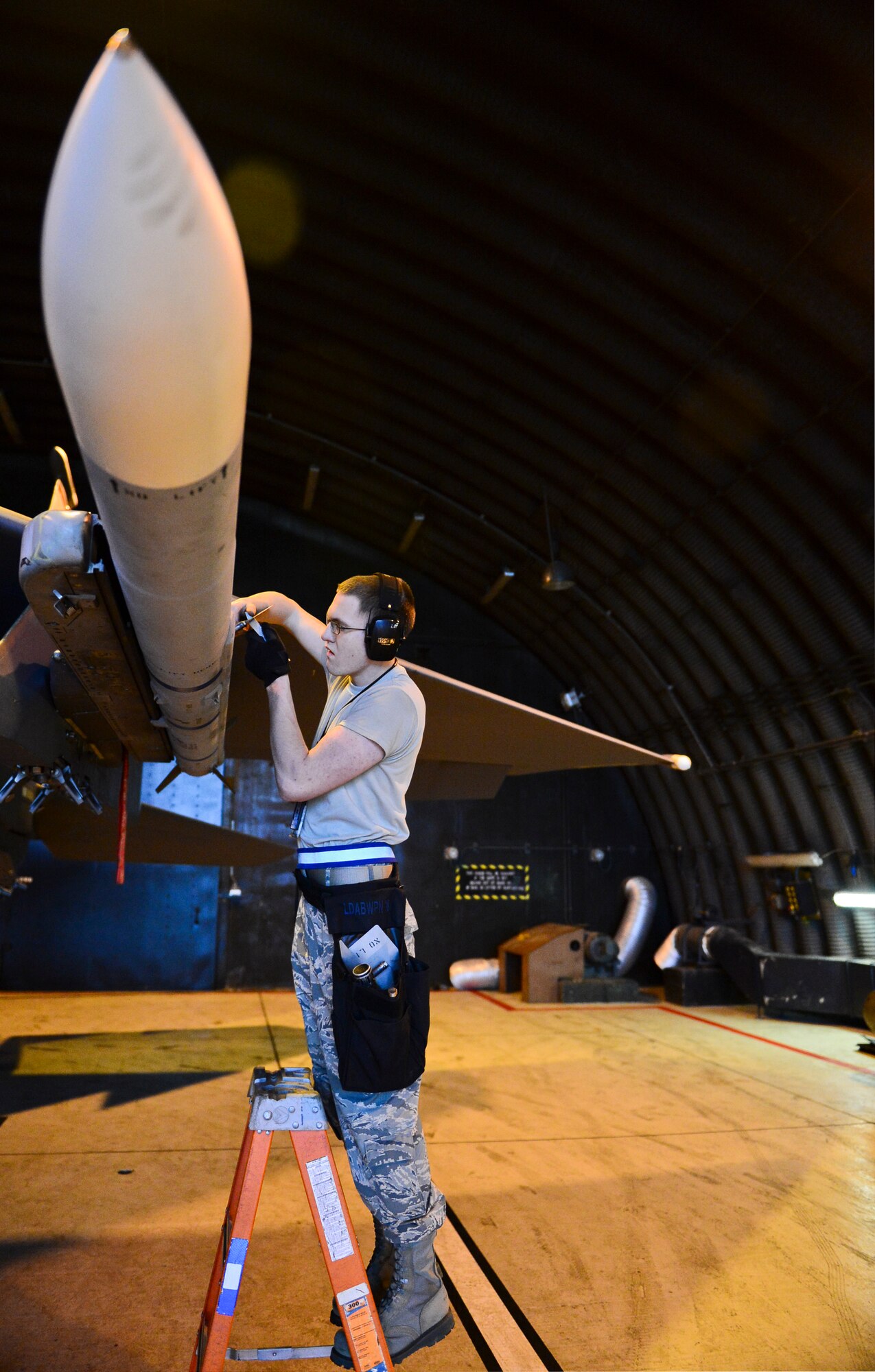 Airman 1st Class Raymond Rizzo, 492nd Aircraft Maintenance Unit load crew member, inspects an AIM-9 munition on an F-15C Eagle during the Load Crew of the Quarter competition at Royal Air Force Lakenheath, England, Jan. 12, 2015. The competition tested teams’ abilities to arm F-15 Eagles in a fast and safe manner.  (U.S. Air Force photo by Airman 1st Class Erin R. Babis/Released)