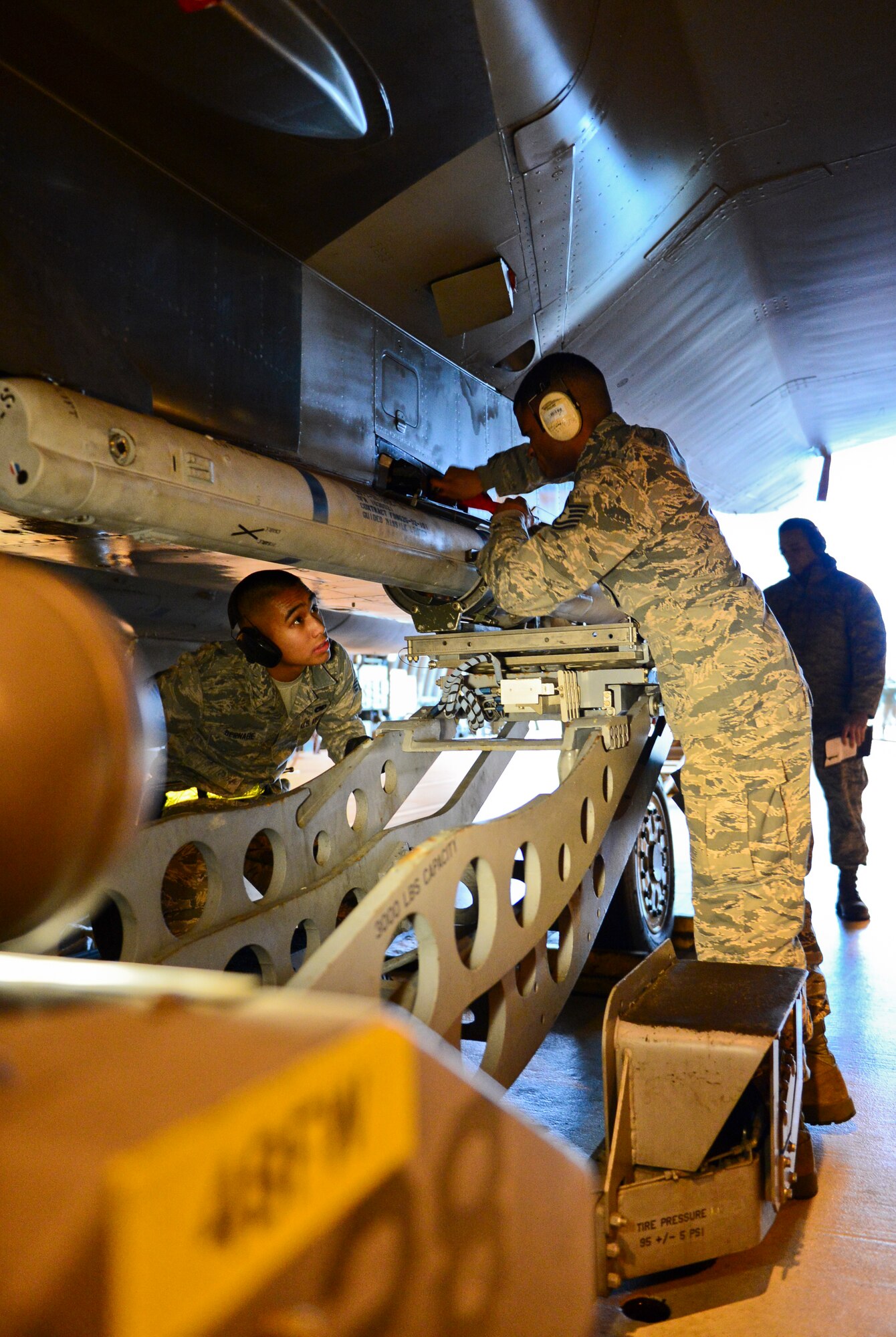 Tech Sgt. Kelvin De Los Santos, weapons crew chief, and Senior Airman Daniel Bernabe, load crew member of the 493rd Aircraft Maintenance Unit prepare an F-15C Eagle for munitions loading during the Load Crew of the Quarter competition at Royal Air Force Lakenheath, England, Jan. 12, 2015. The competition tested teams’ abilities to arm F-15 Eagles in a fast and safe manner. (U.S. Air Force photo by Airman 1st Class Erin R. Babis/Released)