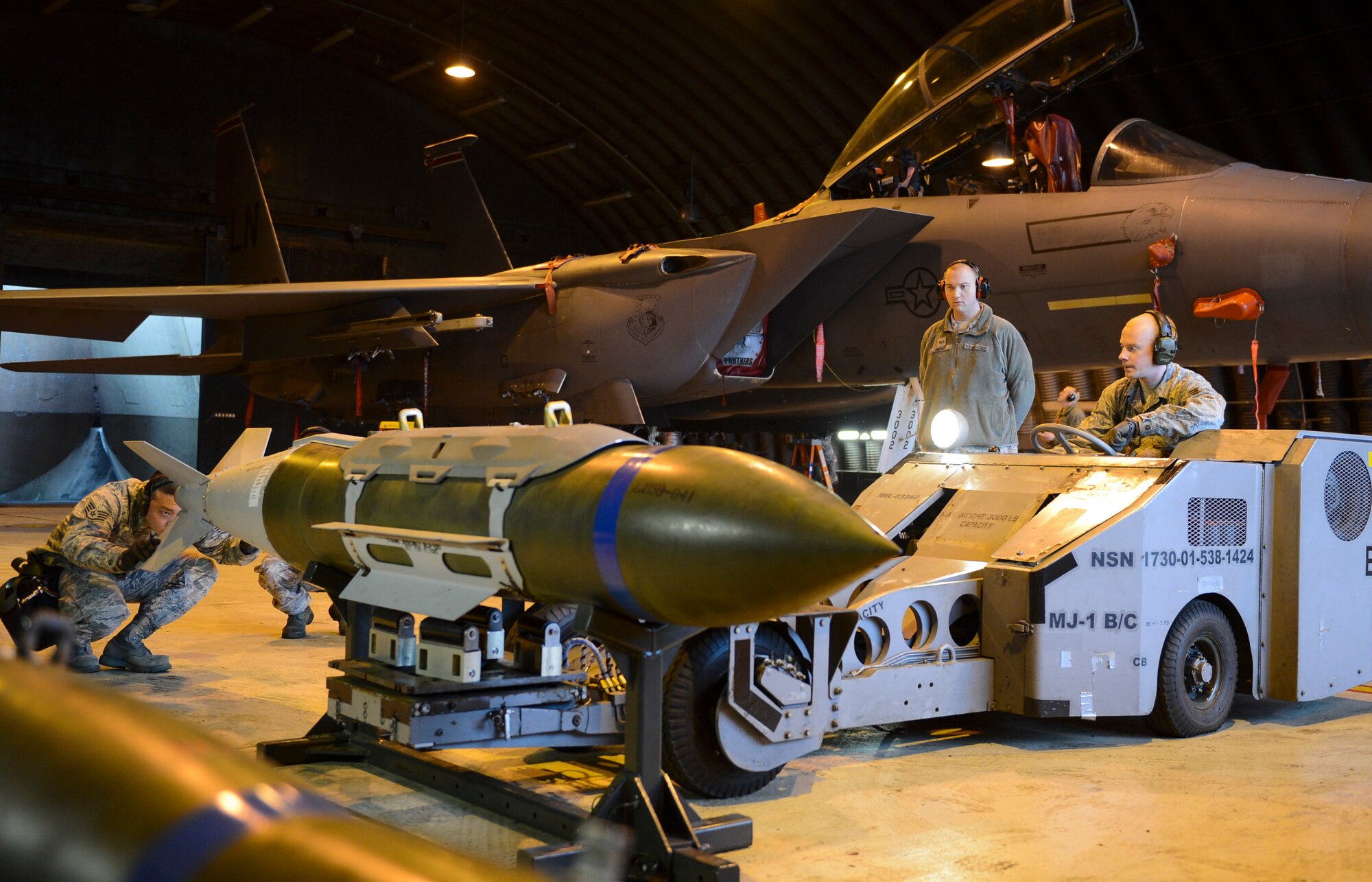 A weapons load crew team from the 492nd Aircraft Maintenance Unit works together to lift a Guided Bomb Unit-31 munition onto an MJ-1 lift truck during the Load Crew of the Quarter competition at Royal Air Force Lakenheath, England, Jan. 12, 2015. The competition tested teams’ abilities to arm F-15C Eagle in a fast and safe manner. The competition was held between the 492nd, 493rd and 494th AMUs. (U.S. Air Force photo by Airman 1st Class Dawn M.Weber/Released)