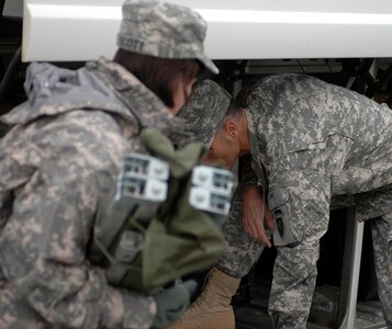 Army Col. R. Allen Boyette, Joint Task Force-Tarheel Executive Officer, and Army Capt. Patrick Brozowski, Joint Task Force -Tarheel Battle Captain, examine the cargo area of a charter bus prior to loading the bus with personal and unit equipment. JTF-Tarheel is composed of service members from the North Carolina National Guard. They are participating in the Alaska National Guard's Vigilant Guard exercise. During the Vigilant Guard exercise the state of Alaska will also be conducting the State of Alaska's Alaska Shield exercise and the Joint Task Force Alaska's Artic Edge exercise. All three of these exercises will be testing the capabilities of the local, state and federal authorities to handle a natural disaster, pending one occurred in the state of Alaska.