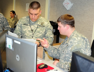 Alaska Army National Guard Soldier Spc. Kenneth Wilson, Joint Operations Center information knowledge manager explains the process of importing information into the Joint Information Exchange Environment to Capt. Michael Mussio, National Guard army domestic operations officer, by using the Joint Information Environment all states are able to input, view and coordinate information and respond to any real world or exercise scenario, such as Vigilant Guard 2010. Vigilant Guard 2010 is a premiere joint training exercise, designed to increase interoperability among federal, state and local volunteers in case of a disaster