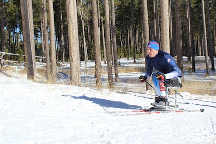 Bryan Price, a member of the Paralympic biathlon team, charges his way up a hill, propelling his body with his upper body strength during a training camp on Casper Mountain, Nov. 20, 2014.
 