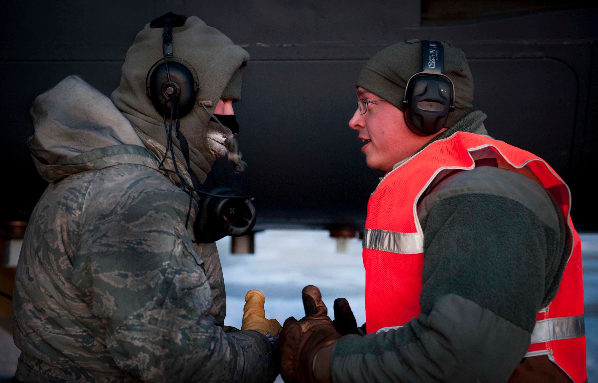 Senior Airman Taylor Lancaster speaks to a maintenance Airman Jan. 9, 2014, on Minot Air Force Base, N.D. Lancaster ensures his jet is fixed and prepared to take off before its flight time. Lancaster is a 5th Aircraft Maintenance Squadron aircraft crew chief. (U.S. Air Force photo/Airman 1st Class Sahara L. Fales)