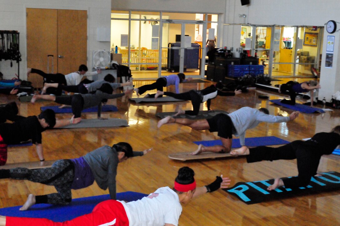 Participants in Friday’s Indo YogaFit Balance Board class at the Barber Physical Activities Center warm up as they begin tuning in both mentally and physically to the challenge of balancing themselves on the lightweight boards.