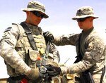 Army Spc. Brandon Sitton, left, helps his brother, Army Pfc. Joshua Sitton, strap on a harness before a mission at Forward Operating Base Orgun, Afghanistan, April 12, 2010.