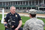 Army Spec. John R. Adkins, 133rd Mobile Public Affairs Detachment of the Kentucky National Guard, interviews Louisville Metro Police Sgt. Jim Bland about their mission during last year's Kentucky Oaks and Derby horse races.