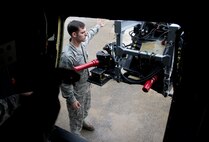 Staff Sgt. Ronnie Simons, 1st Special Operations Aircraft Maintenance Squadron weapons load team chief, helps insert a 25mm Gatling gun into an AC-130U Gunship on the flightline at Hurlburt Field, Fla., Jan. 12, 2015. The weapons flight Airmen fix and maintain the weapons systems on the AC-130U. (U.S. Air Force photo/Senior Airman Krystal M. Garrett)