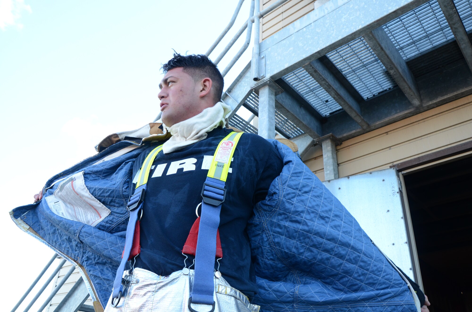 Senior Airman Warren Duke, a firefighter with the 624th Civil Engineering Squadron, removes his fire proximity suit after participating in a live-fire training exercise at Hickam Field, Hawai’i, Jan. 10, 2015. The silver bunker suit is used by the Air Force to protect firefighters from the extreme temperature of an aircraft fire. (U.S. Air Force photo by Tech. Sgt. Phyllis Keith)