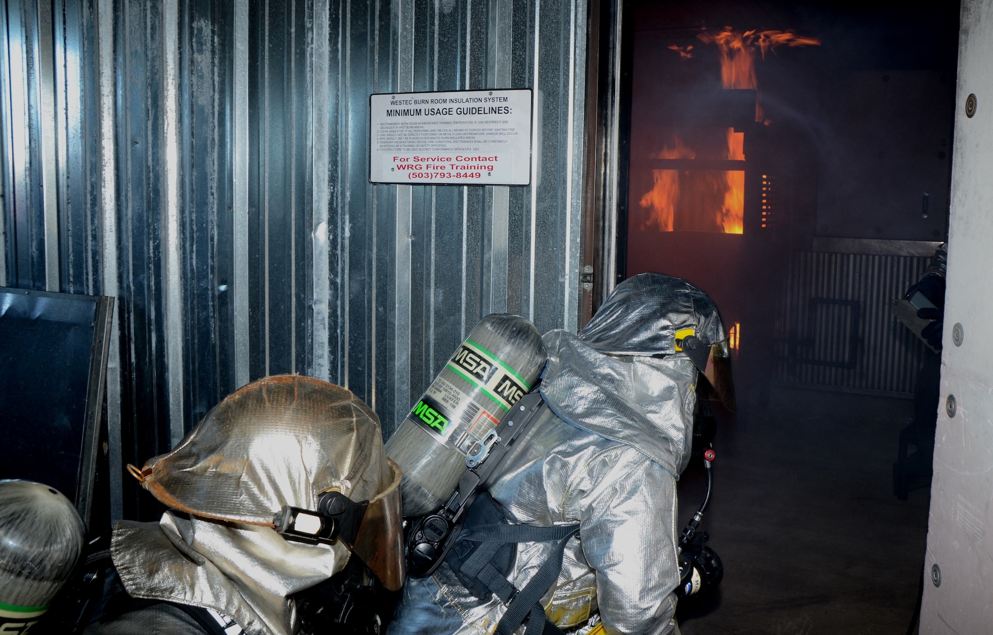 Two firefighters with the 624th Civil Engineering Squadron, enter a room engulfed in flames during a live-fire burn exercise, Hickam Field, Hawai'i, Jan. 10, 2015. Propane gas was used to simulate a kitchen fire, giving the reservists hands-on training in structural firefighting skills. (U.S. Air Force photo by Tech. Sgt. Phyllis Keith)

