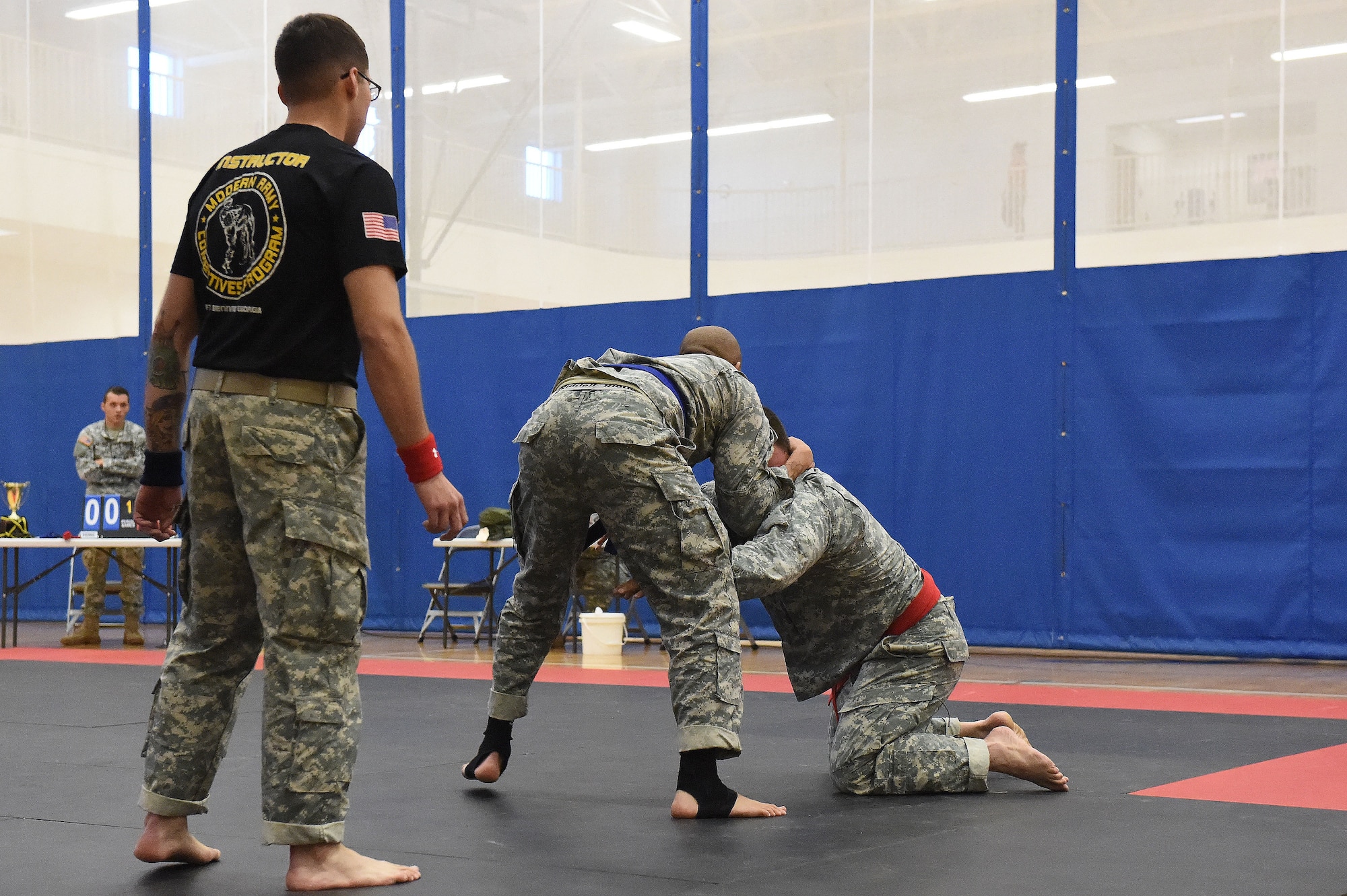 A combatives training instructor judges two U.S. Army 743rd Military Intelligence Battalion Squadron members as they compete for commander’s cup points during a combatives tournament at the Buckley Fitness Center Jan. 15, 2015, on Buckley Air Force Base, Colo. The army battalion hosts the tournament every year to hone hand-to-hand combat training techniques while engaging in friendly competition. (U.S. Air Force photo by Airman 1st Class Samantha Saulsbury/Released)
