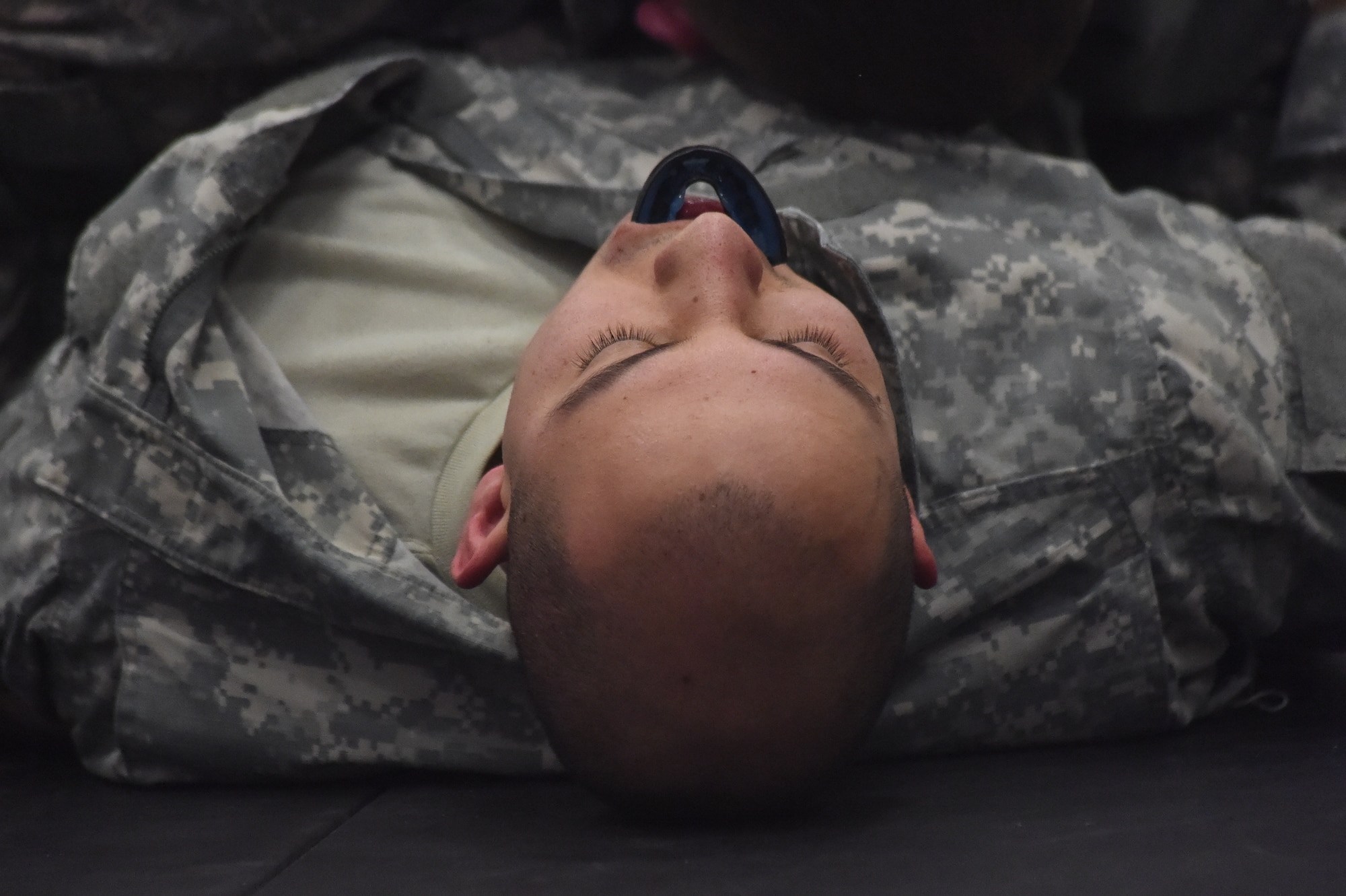A U.S. Army 743rd Military Intelligence Battalion member lies defeated after competing in a combatives tournament held at the Buckley Fitness Center Jan. 15, 2015, on Buckley Air Force Base, Colo. The army battalion hosts the tournament every year to hone hand-to-hand combat training techniques while engaging in friendly competition. (U.S. Air Force photo by Airman 1st Class Samantha Saulsbury/Released)
