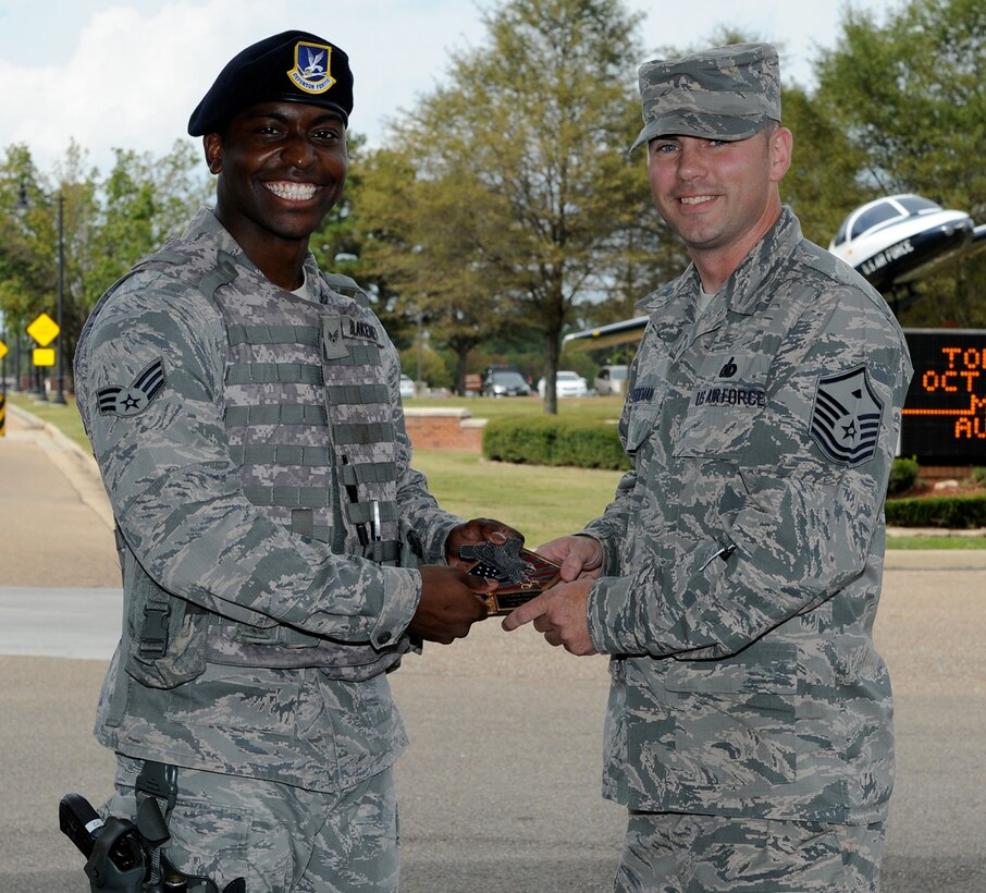 Senior Airman Calvin Blakeney, 14th Security Forces Squadron, is presented the Diamond Sharp Award for the third quarter of 2014 by Master Sgt. Jeremy Heideman, 14th SFS First Sergeant, Oct. 8 at Columbus Air Force Base, Mississippi. Blakeney was recognized on numerous occasions for his above-and-beyond manner in which he greets those entering the base, most notably by Col. John Nichols, 14th Flying Training Wing Commander, and Mr. Mark A. Smith, Air Education and Training Command appointed representative to the Commander. (U.S. Air Force photo/Elizabeth Owens)