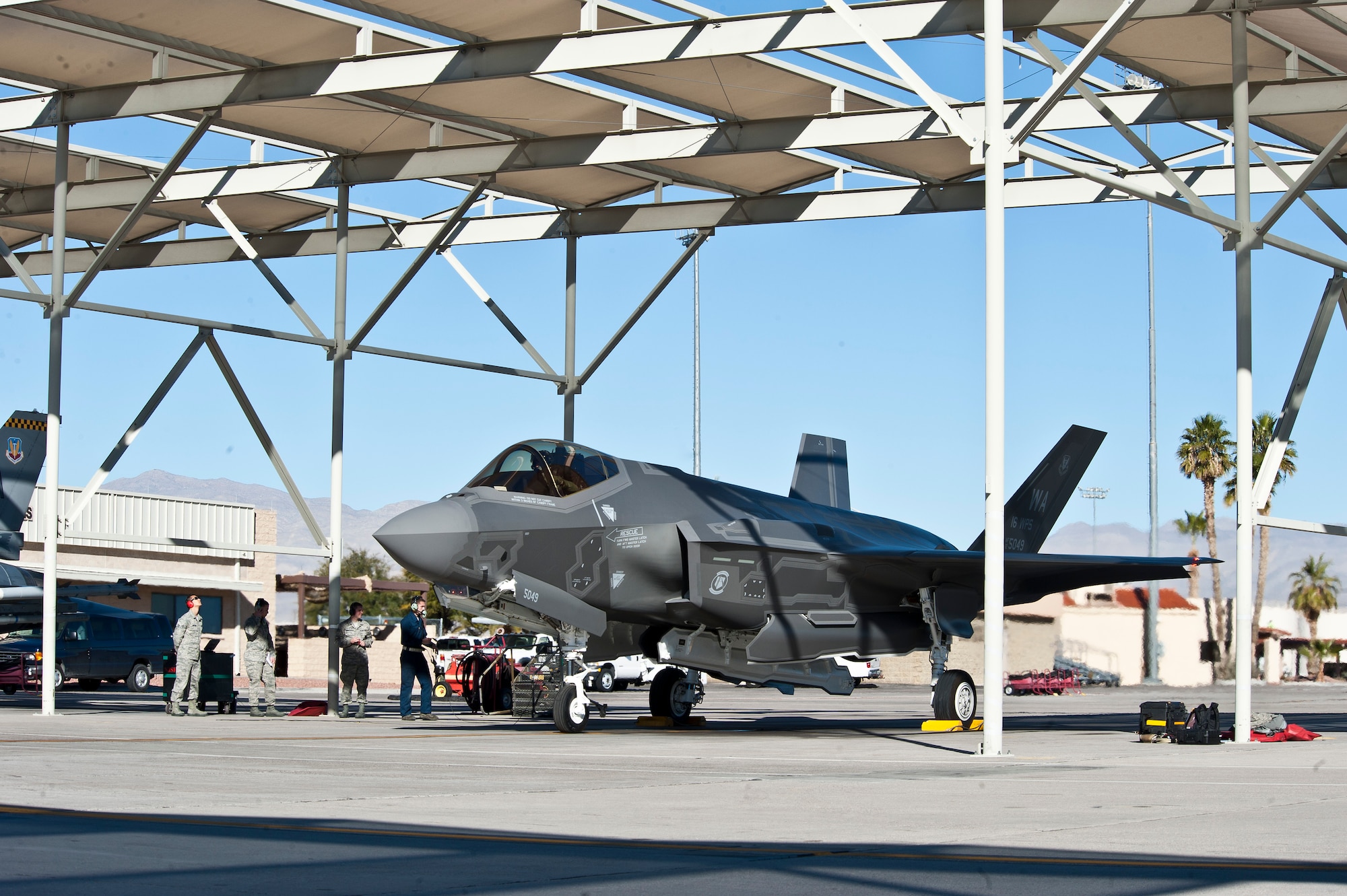 The U.S. Air Force Weapons School’s first assigned F-35A Lightning II sits under a sun shade on the flightline at Nellis Air Force Base, Nev., Jan. 15, 2015. Working in conjunction with the U.S. Air Force Warfare Center and 422nd Test and Evaluation Squadron, the USAFWS’ first F-35 will be used to drive tactics development. (U.S. Air Force photo by Airman 1st Class Mikaley Towle)

