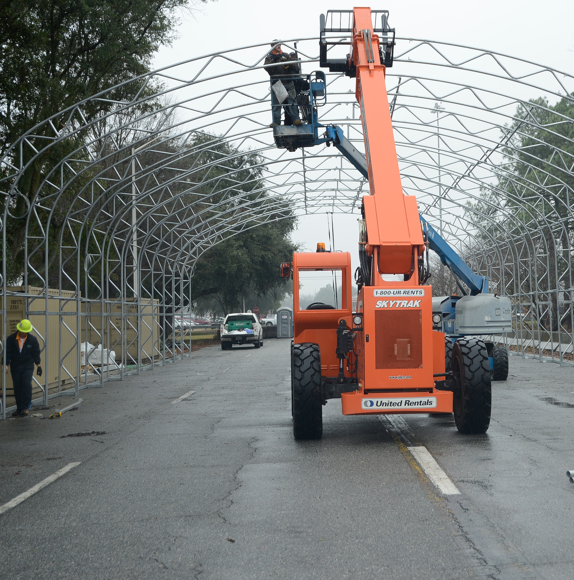 Despite inclimate weather, contractors still work on erecting the commercial gate’s overhead canopy, Jan. 13, 2015. (U.S, Air Force photo by Ed Aspera)