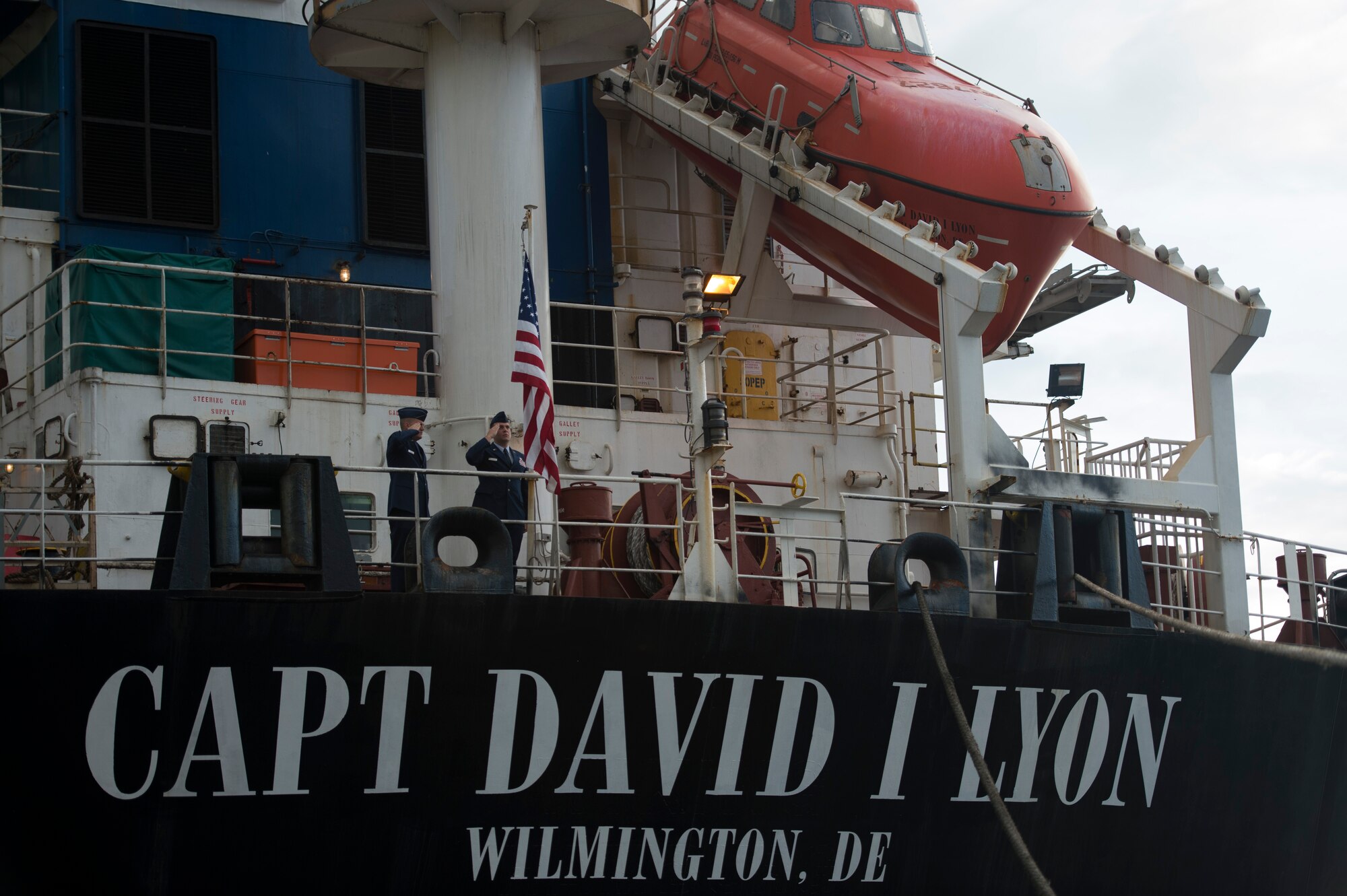 Capt. Jonathan Tolman and Staff Sgt. Charles Taherimorovat render a salute to the American flag during reveille onboard the Motor Vessel Capt. David I. Lyon before the vessel's christening Aug. 11, 2014, at Military Ocean Terminal Sunny Point in Southport, N.C. The MV Capt. David I. Lyon is an Air Force prepositioning vessel named in honor of Capt. David I. Lyon, an Air Force logistics readiness officer and 2008 U.S. Air Force Academy graduate who was killed in action Dec. 27, 2013, in Afghanistan. The vessel will transport critical war reserve materiel to locations around the globe. (U.S. Air Force photo/Tech. Sgt. Jason Robertson) 