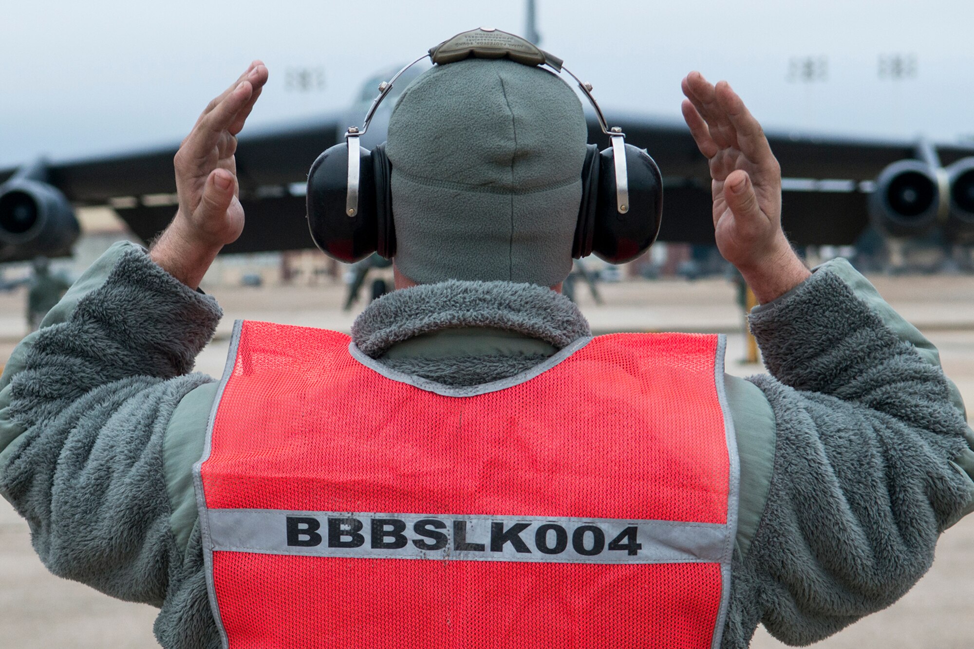 U.S. Air Force Senior Airman Spencer Leger, 707th Aircraft Maintenance Squadron crew chief, marshals a B-52H Stratofortress to a parking spot after its return from a mission on Jan. 10, 2015, Barksdale Air Force Base, La. On board the aircraft is Col. Michael Adderley, Air Force Global Strike Command Chief of Safety, and this marks his last flight in a B-52 before retiring after more than 20 years of military service. (U.S. Air Force photo by Master Sgt. Greg Steele/Released)
