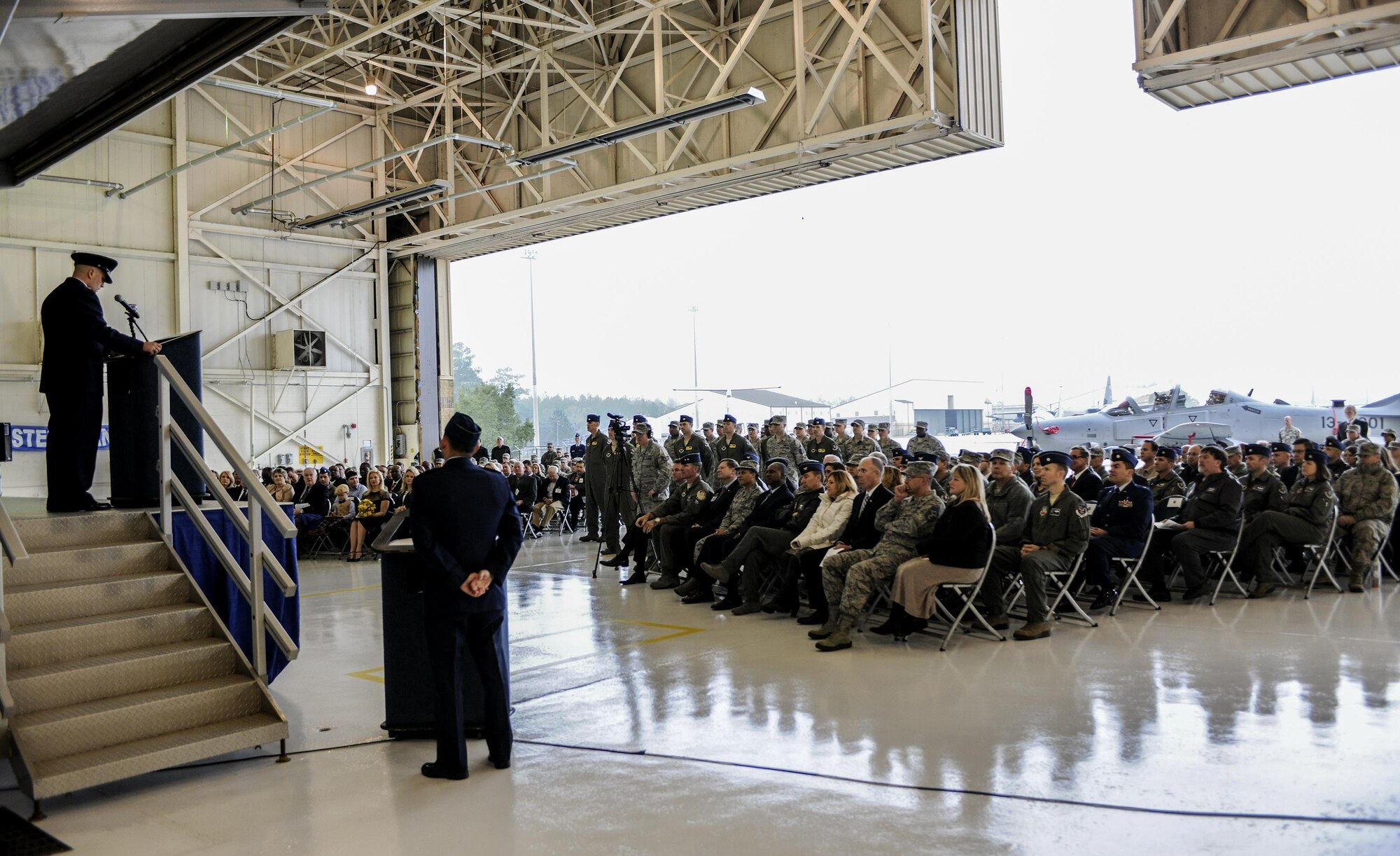 U.S. Air Force Lt. Col Jeffrey Hogan, 81st Fighter Squadron commander, addresses the crowd during activation ceremony and assumption of command Jan. 15, 2015, at Moody Air Force Base, Ga. The 81st FS will train up to 30 Afghan pilots and 90 maintainers on the A-29 Super Tucano, which serves as a backdrop for the historic ceremony.  (U.S. Air Force photo by Senior Airman Sandra Marrero/Released)