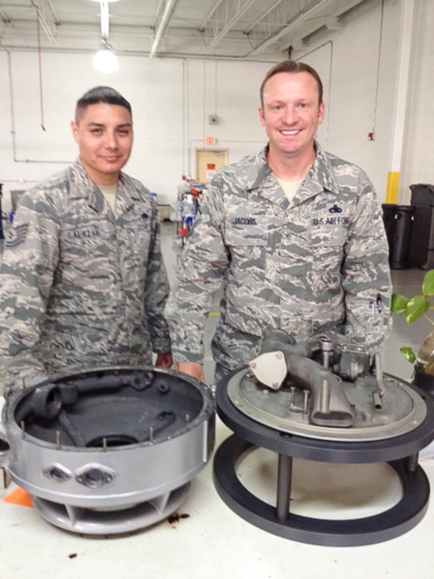 Tech. Sgt. Joseph Salazar, 12th Air Force (Air Forces Southern) Noncommissioned officer in charge of Tactical Aircraft, and Master Sgt. Jeremy Jacobs, 12th Air Force (Air Forces Southern) Tactical Aircraft Manager, smile after examining different sections of the PT6A turboprop engine on Dec. 15, 2014 in Miami, Fl. As part of building partner capacity, personnel in the aircraft maintenance and munitions branch provide aviation maintenance support by offering technical advice to partner nations for maintaining their fleet of aircraft. (Courtesy Photo)