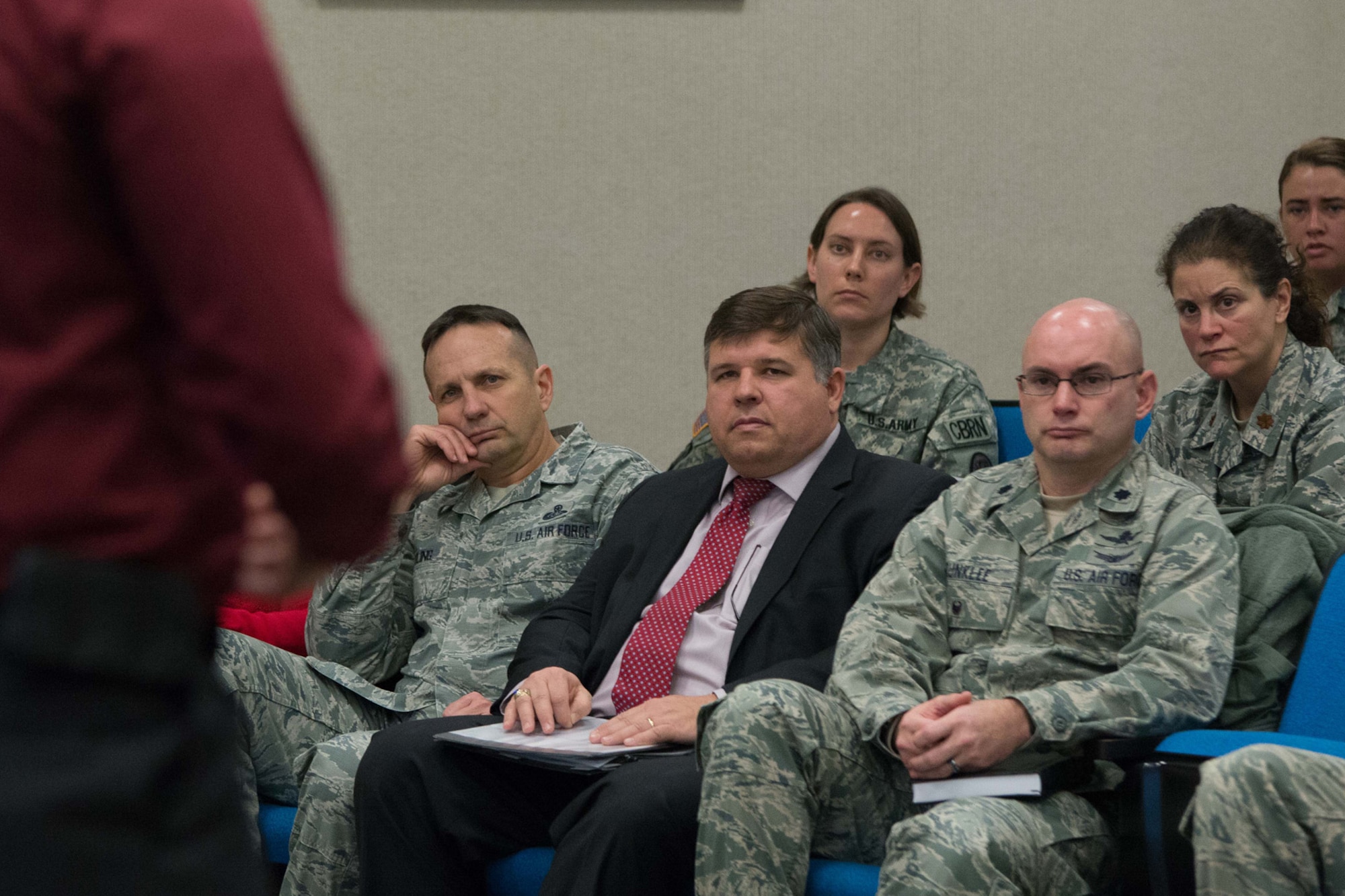 Hanscom Command Chief Master Sgt. Craig A. Poling, Thomas Fredericks and Lt. Col. David R. Dunklee listen as a sexual assault survivor breaks their silence during a Silence to Survivor Sexual Assault Prevention and Response office event at the Hanscom Conference Center Jan. 13. Two survivors spoke about their assaults to members of the community to further promote sexual assault awareness. (U.S. Air Force photo by Mark Herlihy)
